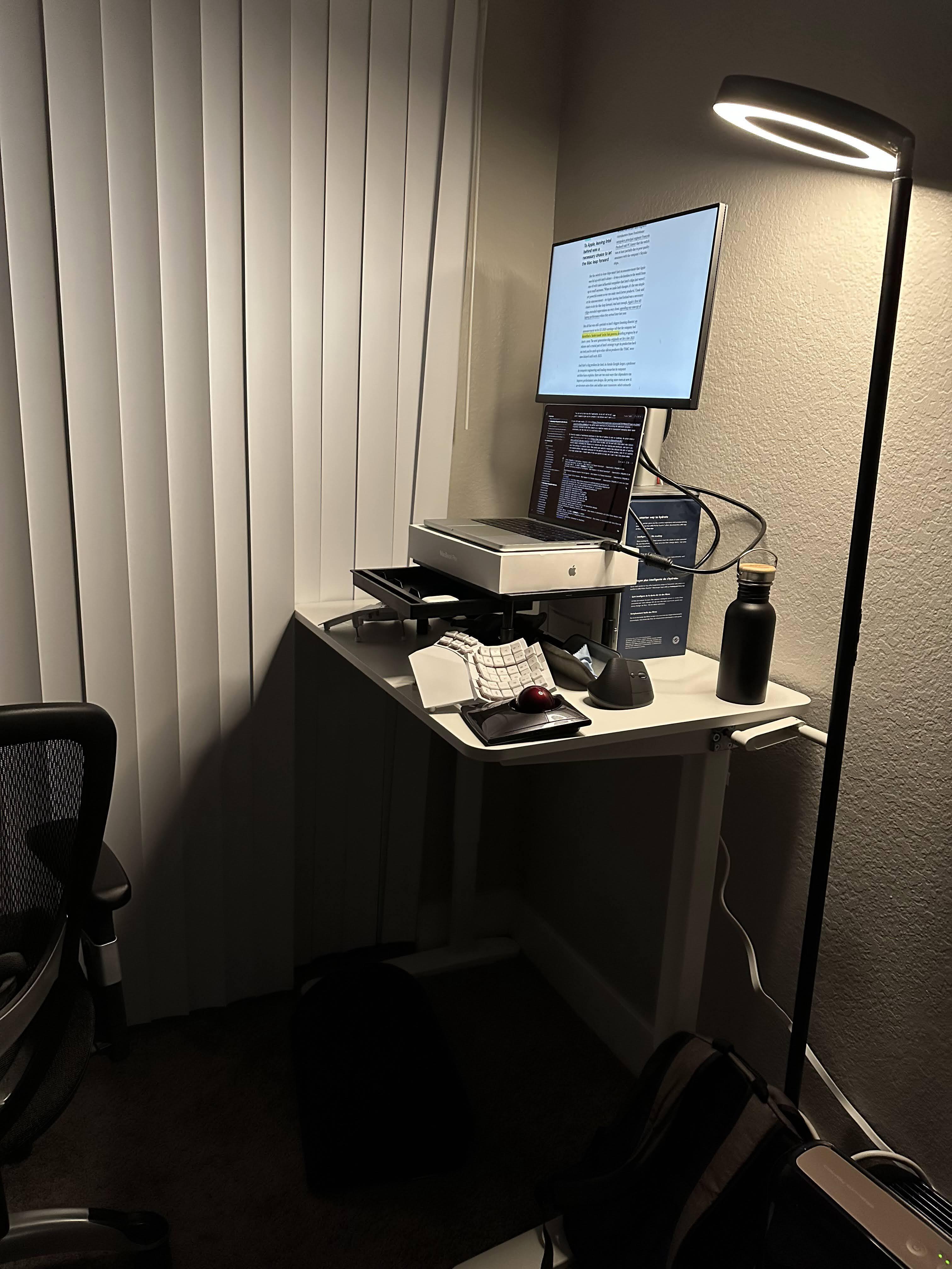 A standing desk and a laptop raiser are useful ergonomic compliments