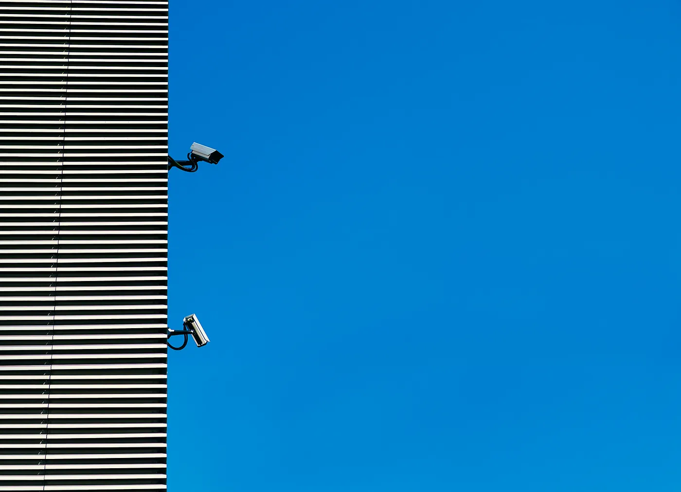 Security cameras on a wall. Photo by Arthur Mazi on Unsplash
