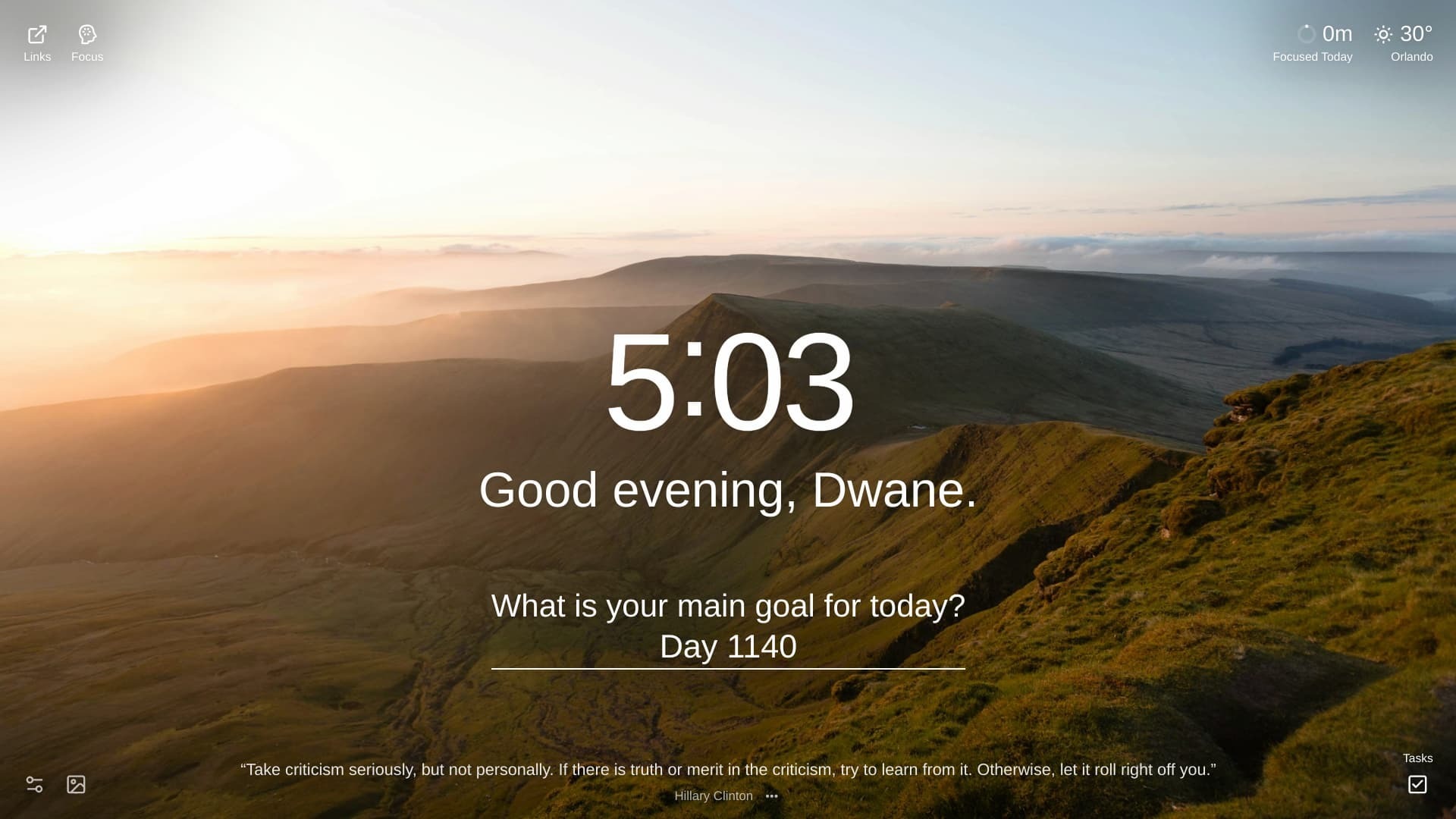 A serene landscape featuring rolling green hills and valleys stretching into the distance under a soft, hazy sky at either sunrise or sunset, casting a warm glow on the horizon. The location is Brecon, United Kingdom