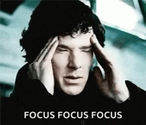 a man is holding his head with his eyes closed and the words focus focus focus behind him .