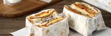 a sandwich that is cut in half and wrapped in paper<br>
