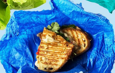 a sandwich wrapped in colorful blue paper