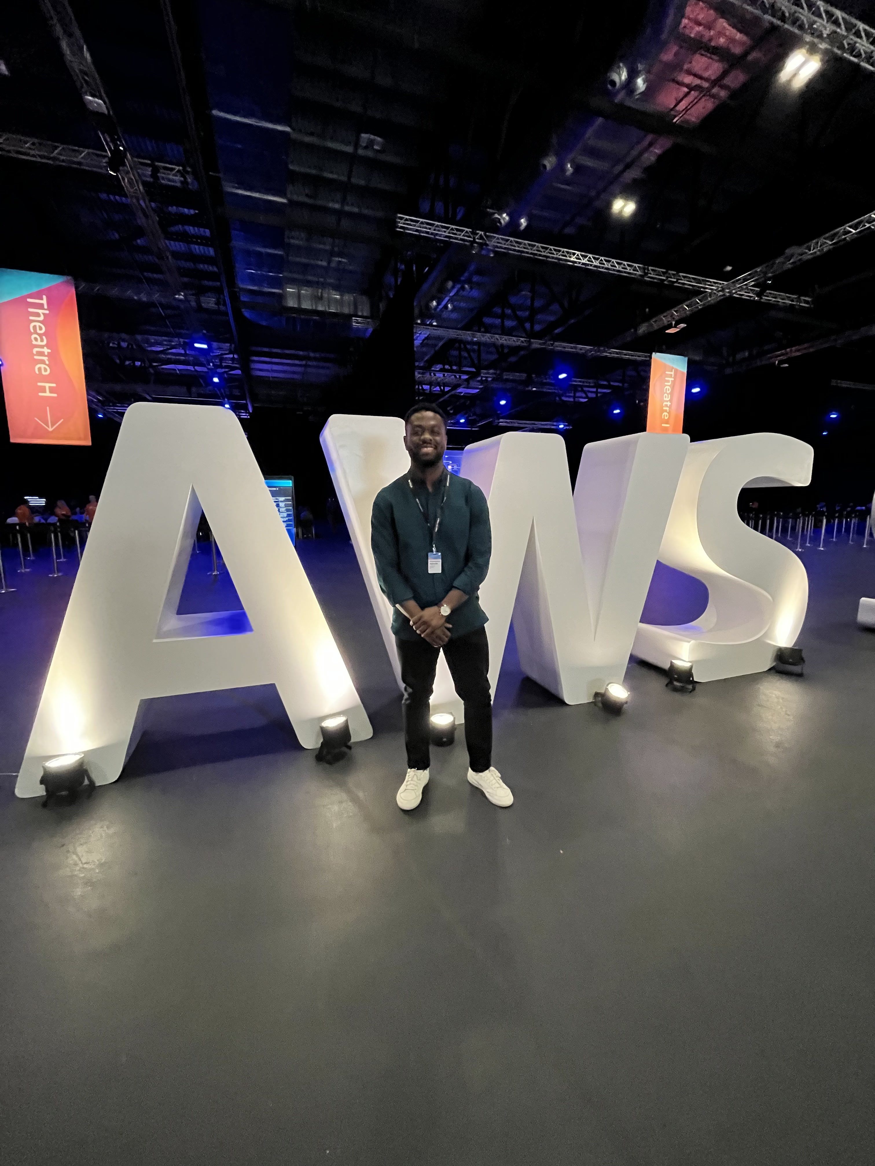 Me standing behind the AWS Logo